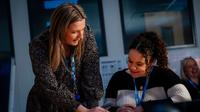 Tutor providing one-to-one support to a student during a classroom session at UCEN Manchester.
