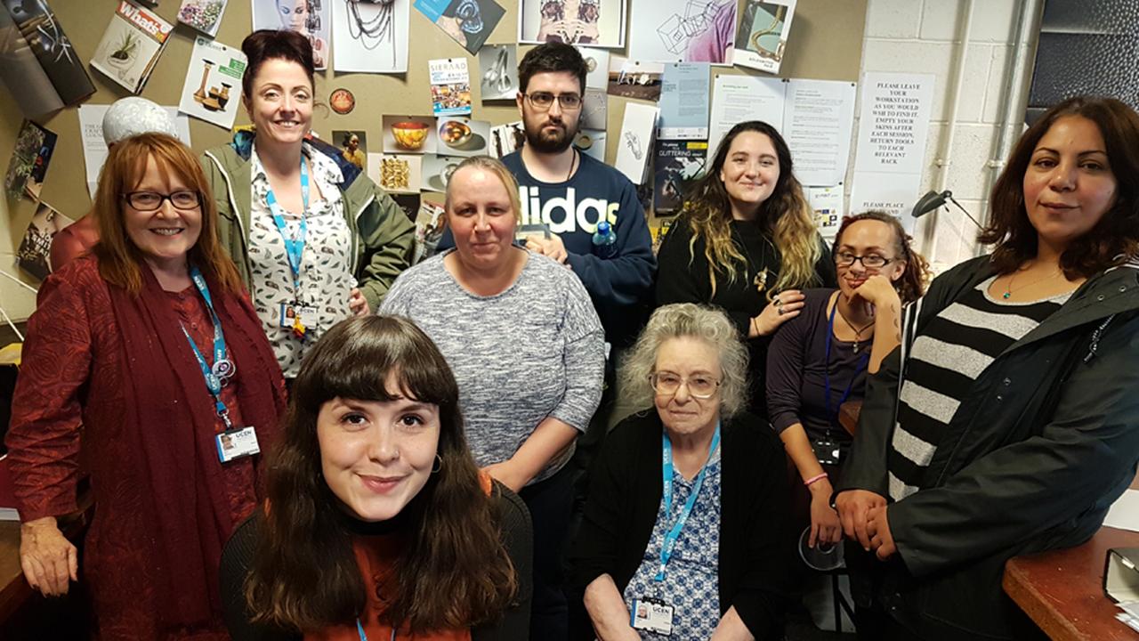 A group of people stood together smiling in a small room