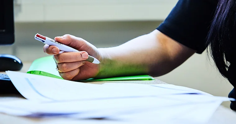 Close-up of someone signing documents