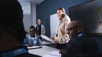 Business student stood presenting in front of her class and tutor